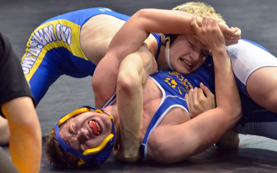 Yokota's Emerson Gaume grimaces as he tries to fight off Christian Academy Japan's Willem Van Dam  during Saturday's 148-pound bout in the Far East Wrestling Tournament Division II dual-meet final. Van Dam decisiioned Gaume 17-10, but Yokota won the meet and its second straight title.