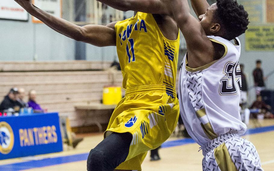 Yokota's Kishaun Kimble-Brooks shoots past Humphreys' Jalen Hill during Tuesday's pool-play game in the Far East Boys Division II Tournament. The Panthers won the rematch of last year's final 55-53.