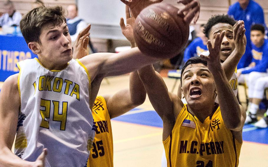 Yokota's Renyck Robertson and Matthew C. Perry's Jon Armijo fight for the ball during Tuesday's quarterfinal game in the Far East Boys Division II Tournament. The Panthers beat the Samurai 73-47.