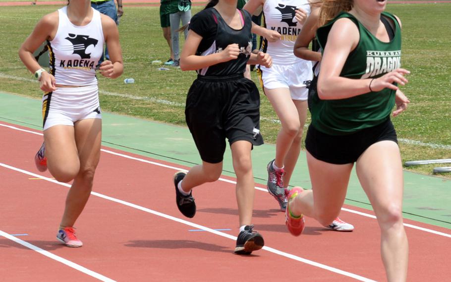 Kubasaki freshman Elizabeth Joy, far right, and Kadena senior Sierra Fitzgerald, far left, pass lapped runners en route to the finish of the 1,600 during Friday's 13th Mike Petty Memorial Track and Field Meet. Joy won in 5 minutes, 46.32 seconds; Fitzgerald was second in 5:47.74.