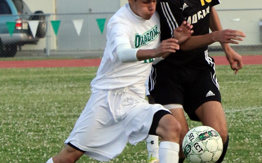 Kubasaki's Adrian Cardenas and Kadena's Guy Renquist battle for the ball during Wednesday's boys soccer match. The Dragons rallied for two second-half goals to win 2-1.