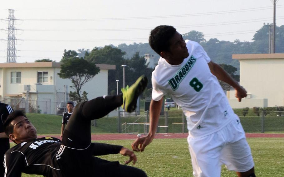 Kadena's Gerald Walton and Kubasaki's Ilijah Washington try to play the ball during Wednesday's boys soccer match. The Dragons rallied for two second-half goals to win 2-1.