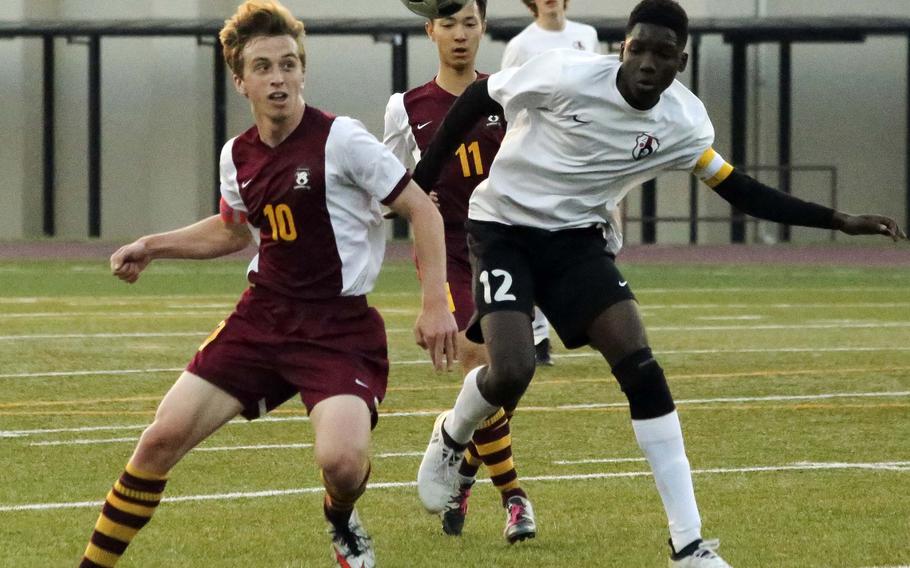 Matthew C. Perry's Aidan Lewis and Zama's Junior Yoplo try to play the ball during Friday's boys soccer match, won by the visiting Samurai 3-2.