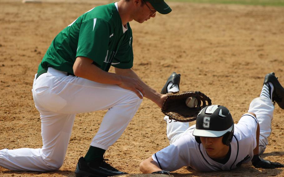 Daegu's Brannin Jackson applies the tag too late on Seoul American's Austin Naughton during Saturday's baseball game, won by the Falcons 8-0.