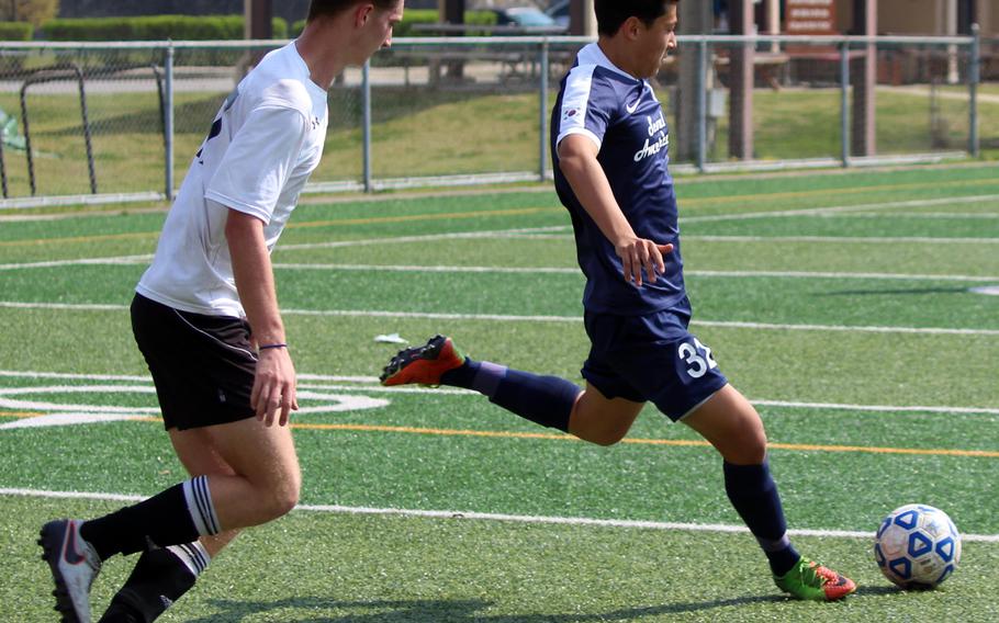 Seoul American's Ben Nagy boots the ball away from Osan's Tyler Smith during Saturday's boys soccer match, won by the Falcons 7-1. Nagy had three goals over the weekend in two matches for the Falcons, who have won three straight.