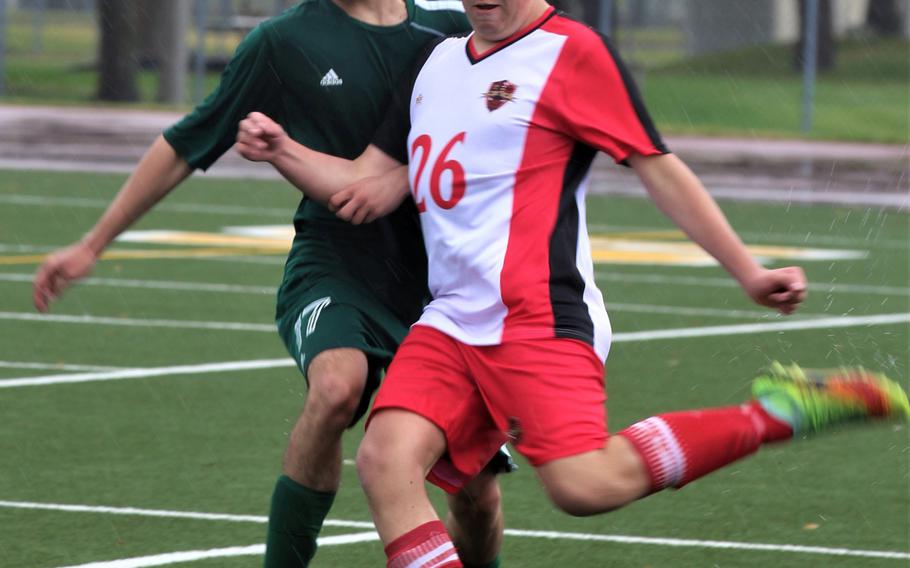 Nile C. Kinnick's Marcus Coca tries to boot the ball past Robert D. Edgren's Seth Salas during Saturday's Japan  boys soccer match, won by the Red Devils 4-0.