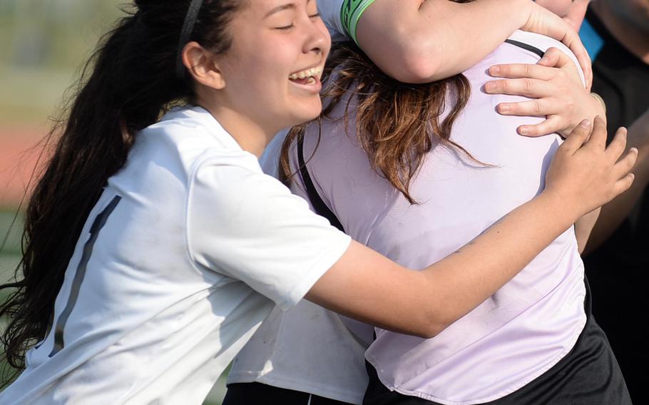 Osan's Kelly Kenyon and Allyson Marek hug goalkeeper Haille Nugent following Saturday's Korea Blue Division girls soccer tournament finals. The Cougars edged Seoul Foreign 3-1 in a penalty-kick shootout for their second straight title.