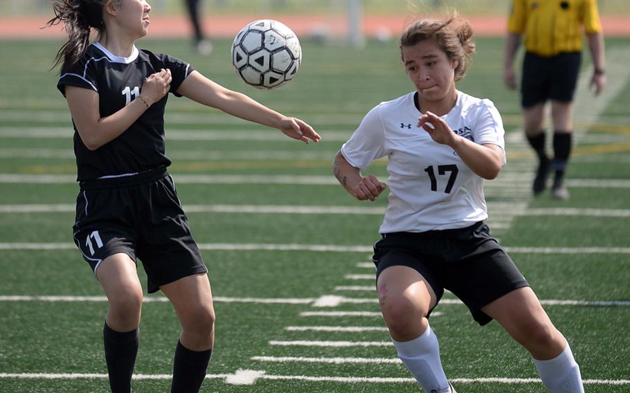 Seoul Foreign's Eunice Ra and Osan's Elizabeth White try to play the ball during Saturday's Korea Blue Division girls soccer tournament finals. The Cougars edged the Crusaders 3-1 in a penalty-kick shootout for their second straight title.