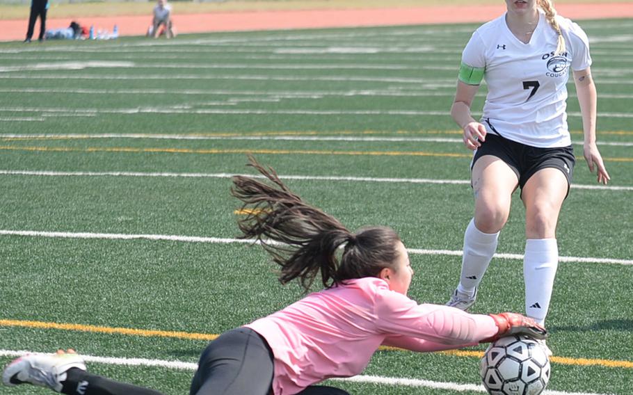 Seoul Foreign goalkeeper Annabelle Davy covers the ball just ahead of Osan's Allyson Marek's arrival during Saturday's Korea Blue Division girls soccer tournament finals. The Cougars edged the Crusaders 3-1 in a penalty-kick shootout for their second straight title.