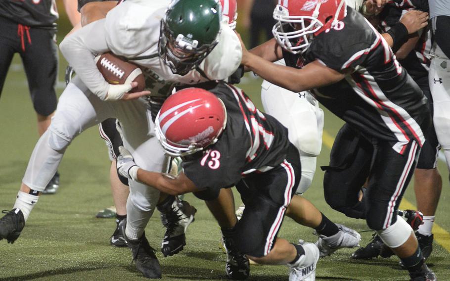 Kubasaki running back Hayden Williamson gets taken down by Nile C. Kinnick's Kameron Leon Guerrero and Alvin Catabayan.