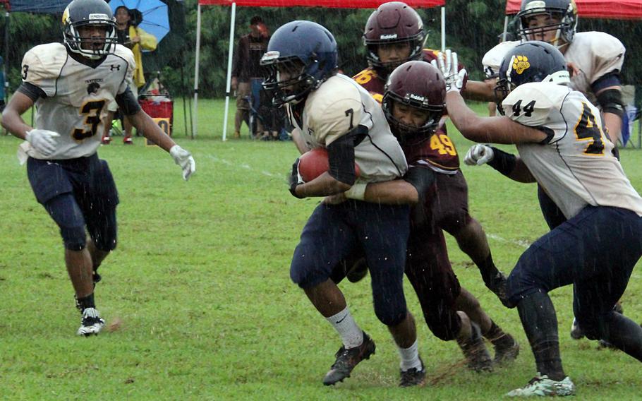 Guam running back Tyrone Rosario struggles through the pouring rain and the defense of two-time island champion Father Duenas Memorial, which blanked the Panthers 30-0 Saturday.