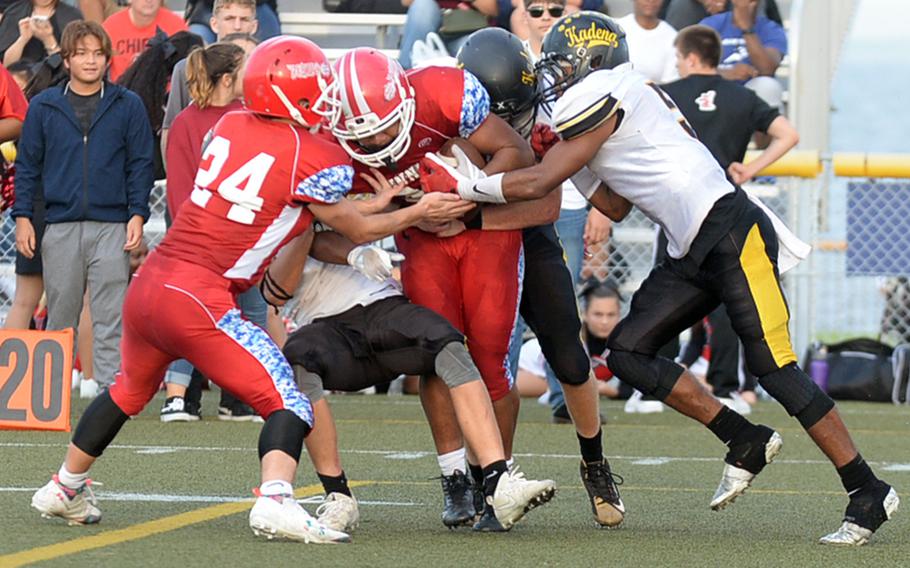 Nile C. Kinnick running back Harry Cheng finds himself surrounded by a gaggle of teammates and Kadena defenders.