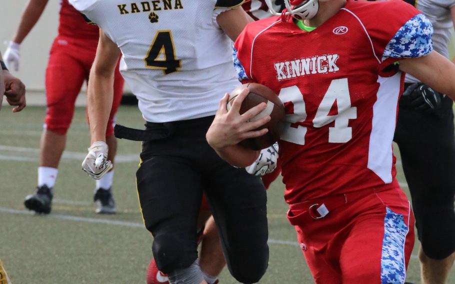 Nile C. Kinnick's Aaron Peterson dashes to the end zone with the game-winning touchdown past Kadena defenders Christian Tsirlis and Brayden Frederick.