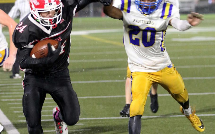 Nile C. Kinnick ball carrier Aaron Peterson steps on the out-of-bounds line as he tries to avert the tackle of Yokota's Jimmy Dewberry.