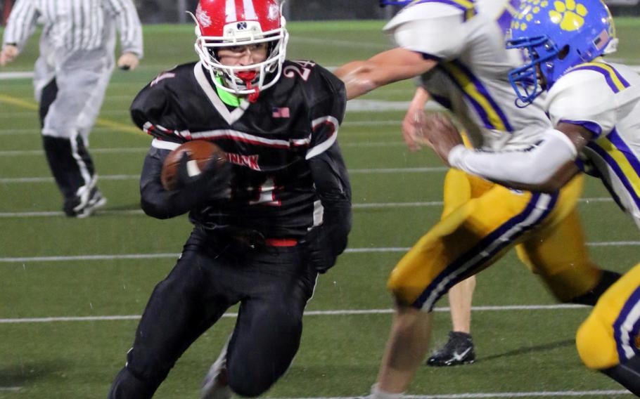 Nile C. Kinnick ball carrier Aaron Peterson charges past Yokota defenders toward the end zone.