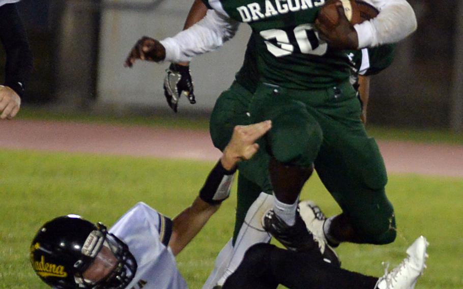 Kubasaki running back Vincent Hill tries to leapfrog the leg tackle of Kadena's Cody Sego.