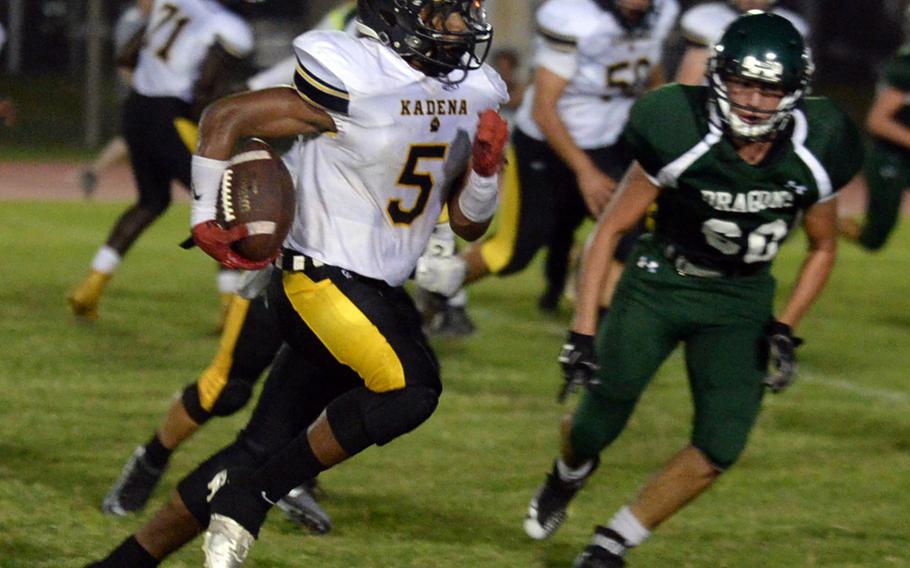 Kadena ballcarrier Eric McCarter dashes toward the end zone past Kubasaki would-be tackler Mason Ayers.