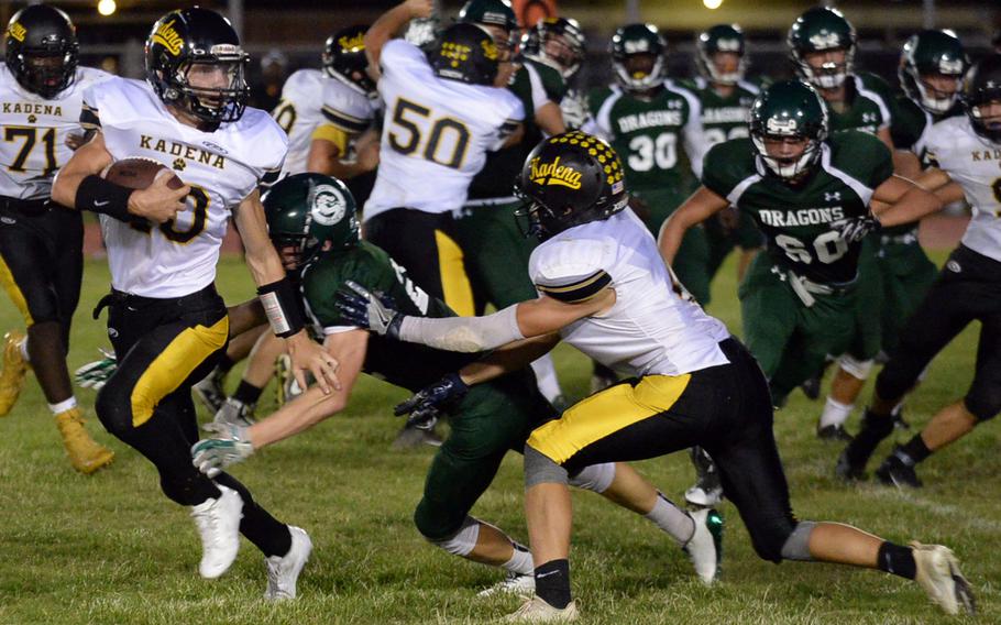 Kadena quarterback Cody Sego looks to elude a Kubasaki tackle.