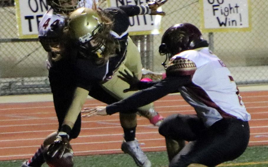 Humphreys receiver Owen Williams stretches for the corner of the end zone between Matthew C. Perry defenders during Friday's football game, won by the Samurai 20-10.