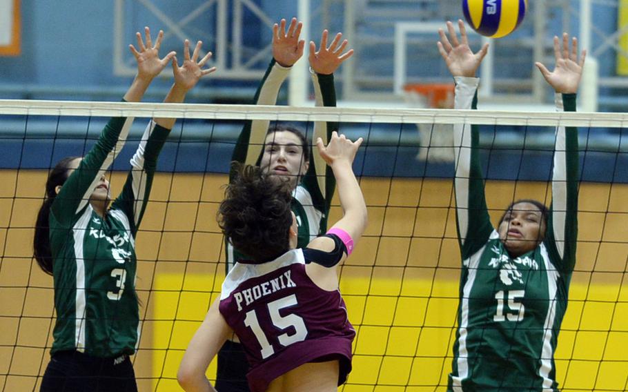 Seisen's Amanda Wood powers a spike through the triple block of Kubasaki's Mimi Larry, Abigail Robinson and Yoselin Johnson during Saturday's American School In Japan-YUJO III girls volleyball tournament. The Phoenix swept the Dragons in straight sets.