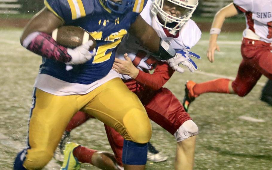 Yokota's Jalen Harrison is wrapped up by Singapore's Chase Meredith during Monday's football game, won by the Panthers 25-6.