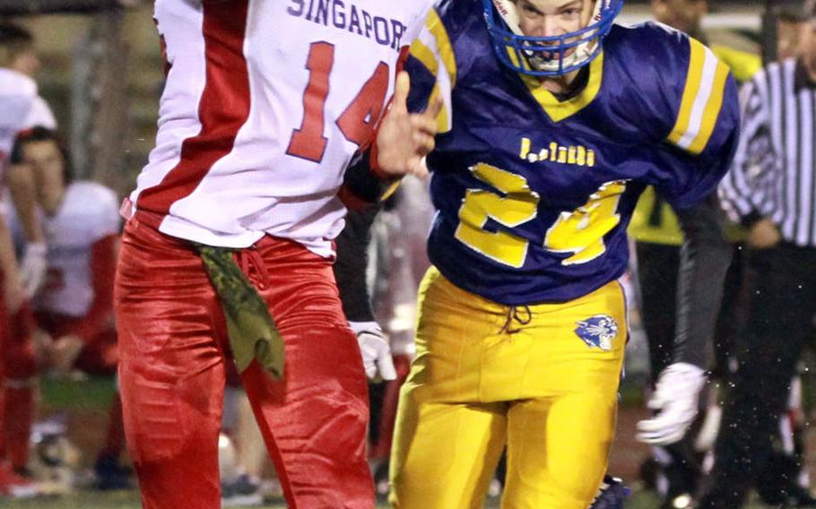 Singapore's Michael White gets rid of the ball just ahead of Yokota defender Eli Phillips during Monday's football game, won by the Panthers 25-6.