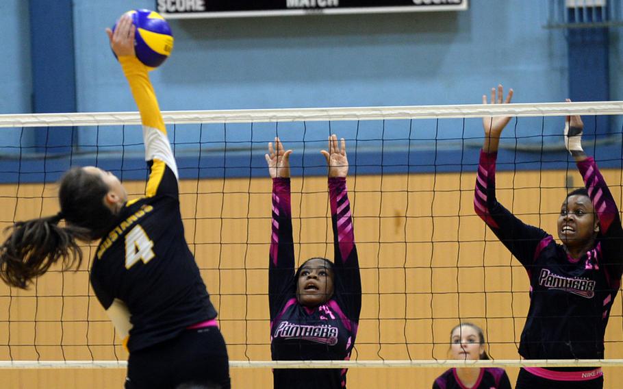 Yokota's Kyra Anderson and Britney Bailey go up to try to block American School In Japan's Kiki Davidson during Wednesday's volleyball match, won by the Mustangs 25-15, 25-19, 28-26.