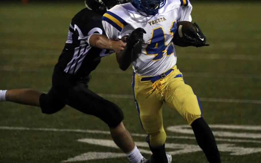 Yokota's Cameron Mister tries to shake free of a Zama defender.