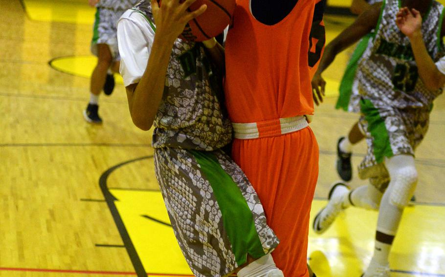 Kubasaki's Elonzo Higginson III plows into a Maehara defender during Saturday's boys basketball game. The Dragons rallied past the Fighting Bulls 81-59.