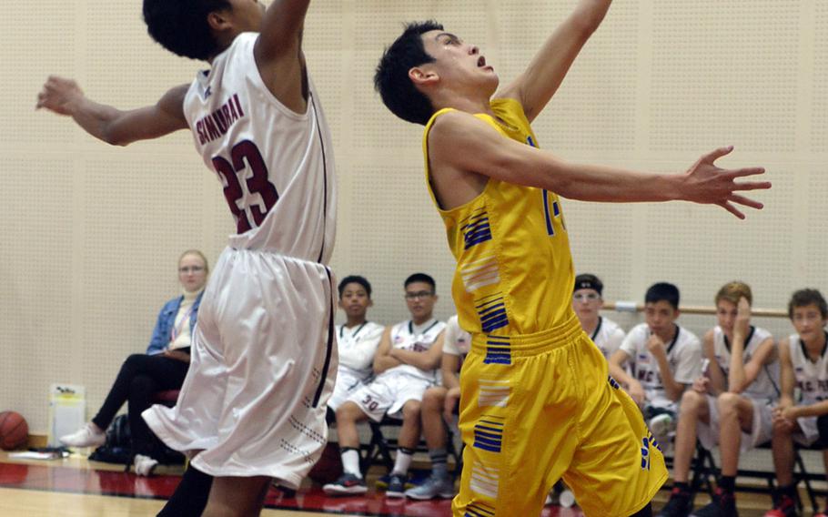 Yokota's David Carlson drives to the basket ahead of Matthew C. Perry's Daniel Riley during Friday's Japan boys basketball game, won by the Panthers 68-48.