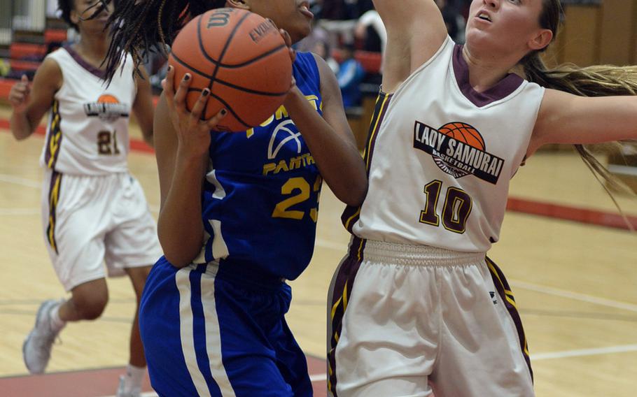 Yokota's Britney Bailey is defended by Matthew C. Perry's Madison Swieczkowski during Friday's Japan girls basketball game, won by the Panthers 44-8.