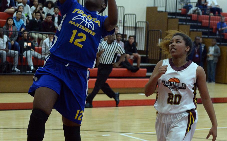 Yokota's Jamia Bailey drives to the basket past Matthew C. Perry's Evianna Thompson during Friday's Japan girls basketball game, won by the Panthers 44-8.