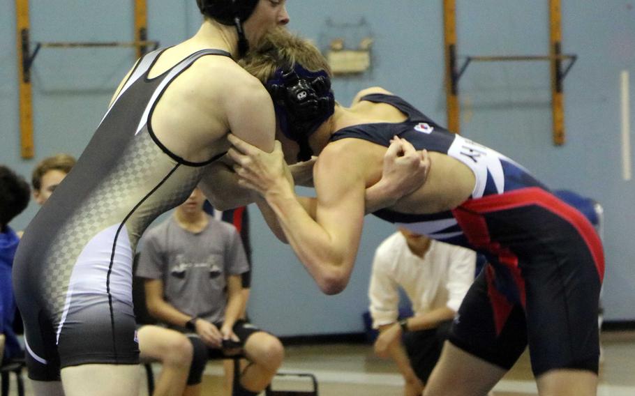 Ben Lister of Humphreys tries to gain control of Seoul American's Ty White during Saturday's three-way dual-meet wrestling event at Seoul American. Lister won the 122-pound bout by technical fall.