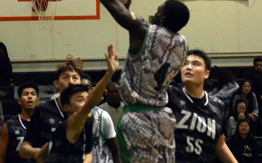 Kubasaki's Vincent Hill skies for a shot over Zion Christian  during Saturday's Okinawa boys basketball game, won by the Dragons 76-48.