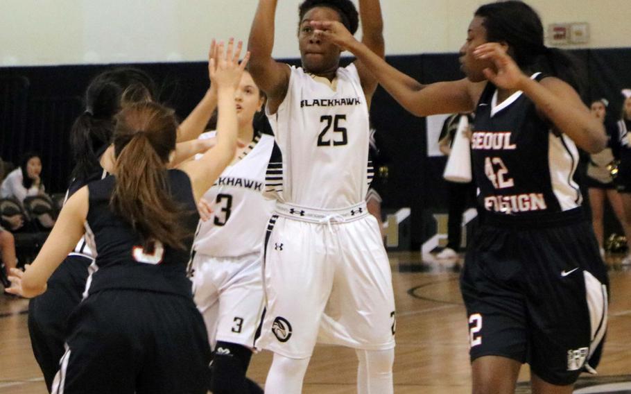 Humphreys' Chakhira Goodwater shoots between three Seoul Foreign defenders during Wednesday's Korea Blue girls basketball game, won by the Crusaders 30-16.