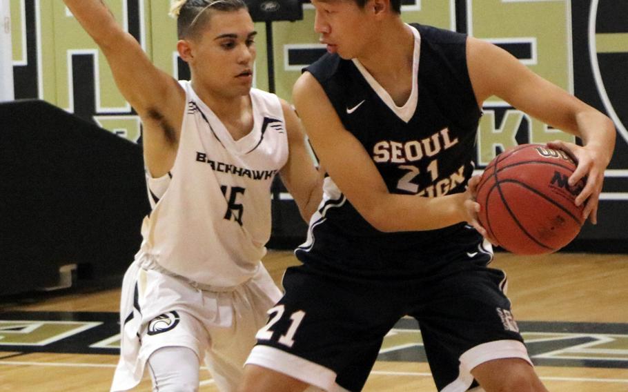 Seoul Foreign's Paul Kim looks for room to operate against Humphreys' Josh Weaver during Wednesday's Korea Blue boys basketball game, won by the Blackhawks 60-50.