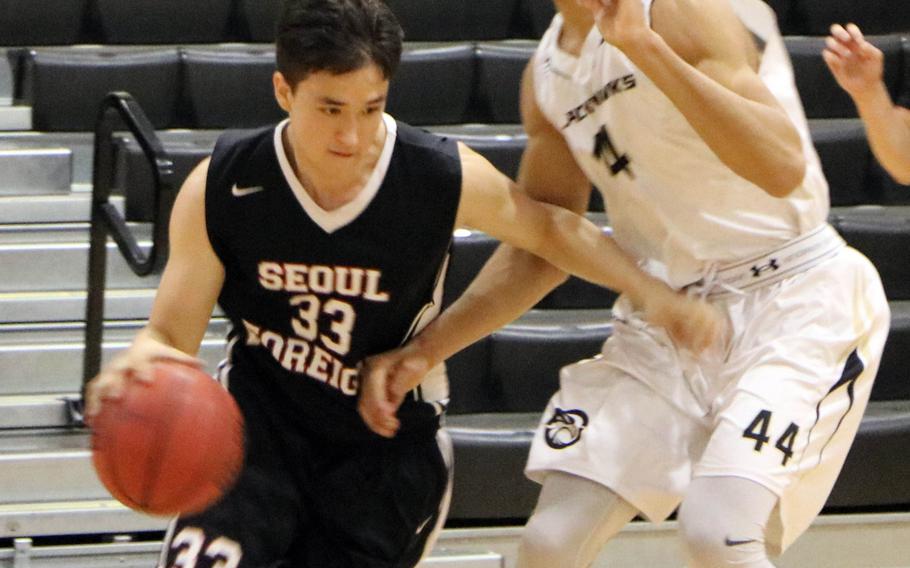 Seoul Foreign's Eugene Linton drives against Humphreys' Quintin Metcalf during Wednesday's Korea Blue boys basketball game, won by the Blackhawks 60-50.