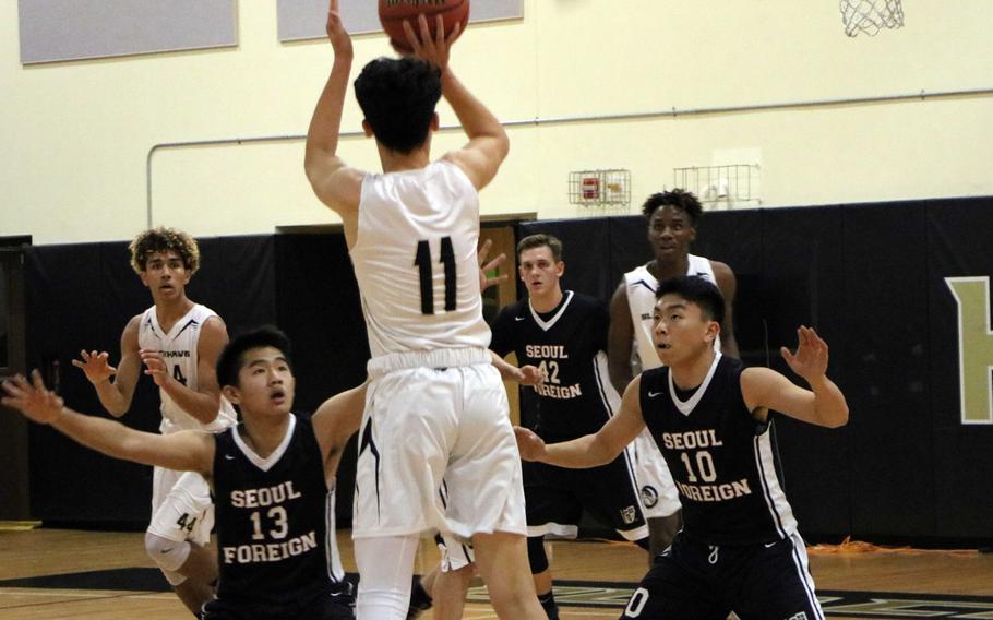 Humphreys' Brice Bulotovich skies for a shot over Seoul Foreign defenders during Wednesday's Korea Blue boys basketball game, won by the Blackhawks 60-50.