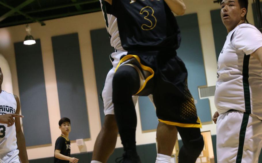Taejon Christian International's Brian Kim drives for a shot against of Daegu's Jonathan Wilson during Wednesday's Korea Blue boys basketball game, won by the Dragons 64-60.