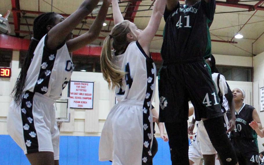 Daegu's DaiJa Turner puts up a shot over two Osan American defenders during Thursday's girls basketball game, won by the Cougars 46-43.