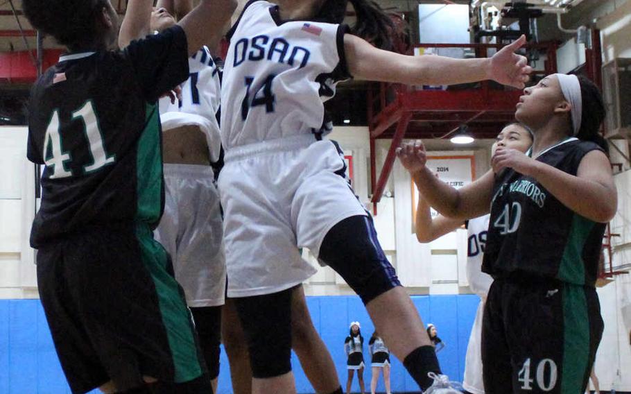 Osan American's Maja Inthavixay skies for a rebound between Daegu's DaiJa Turner and Bethani Newbold during Thursday's girls basketball game, won by the Cougars 46-43.
