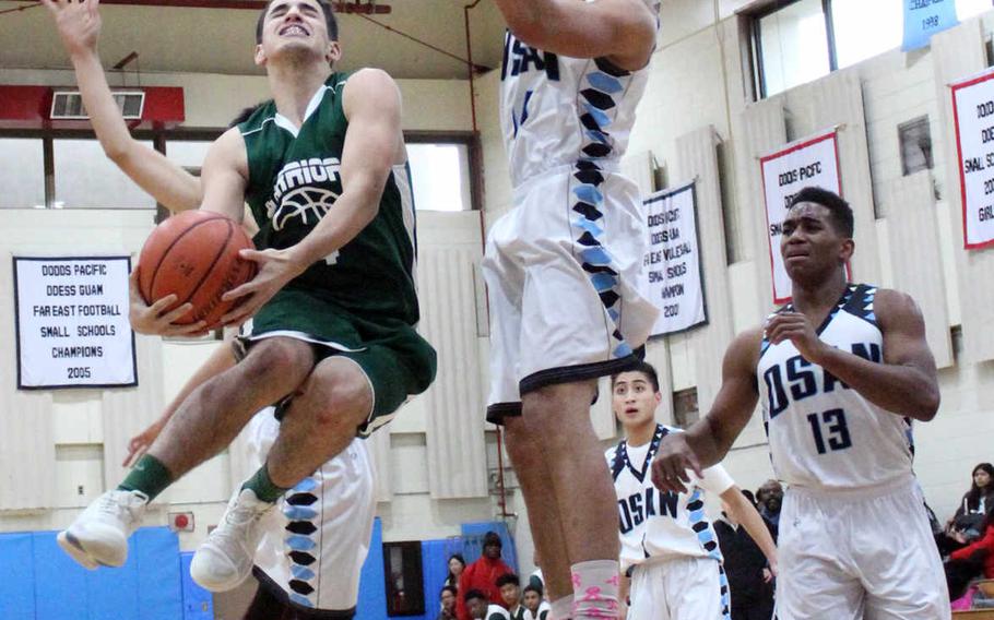 Daegu's Ethan Rodriguez skies for a shot against Osan American's Gabriel Rouse during Thursday's boys basketball game, won by the Cougars 70-57.