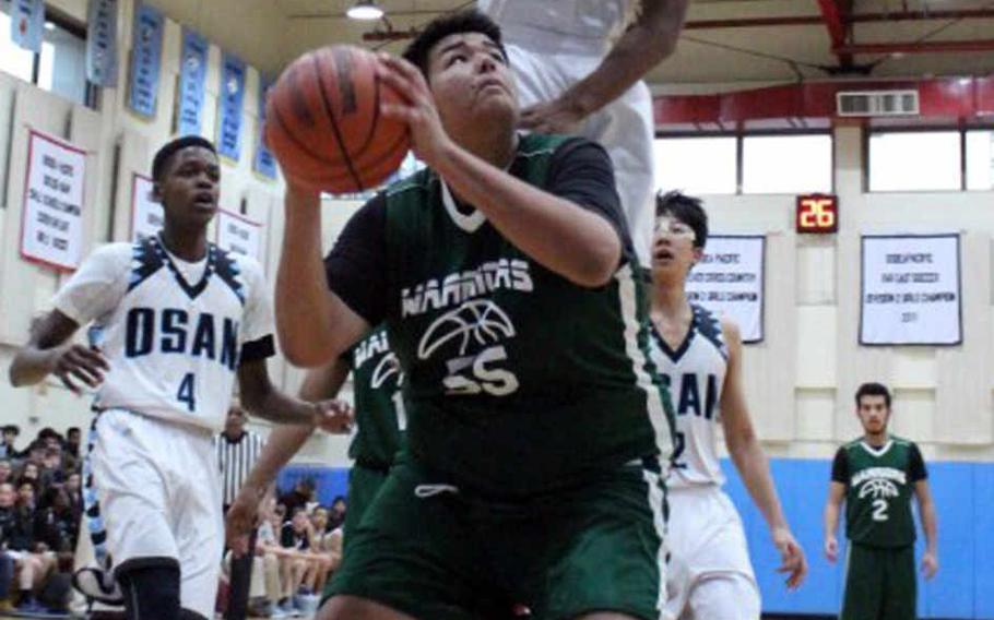 Daegu's Elijah Bembischew looks to put up a shot against Osan American's Cameron Jones during Thursday's boys basketball game, won by the Cougars 70-57.