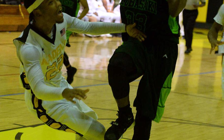 Kubasaki's Damian Dorval collides with Kadena's Eugene Robinson during Friday's boys basketball game, won by the Panthers 40-39.