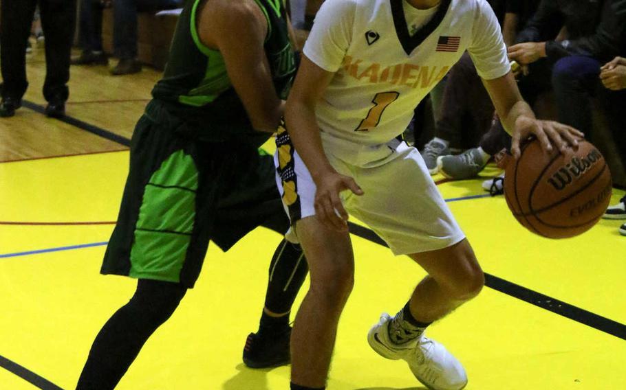 Kadena's Cody Chambers dribbles against Kubasaki's Jhean Natividad during Friday's boys basketball game. Chambers hit a three-point goal just inside the midcourt line as time ran out to rally the Panthers past the Dragons 40-39.