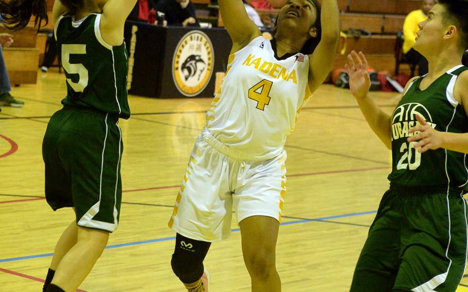 Kadena's Rhamsey Wyche puts up a shot between Kubasaki's Audrey Kerr and Ari Gieseck during Friday's girls basketball game, won by the Panthers 52-15.