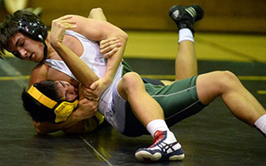 Kubasaki's James Carpenter secures a head-and-arm hold on Kadena's Paul Maskery in the 129-pound bout during Wednesday's Okinawa wrestling dual meet. Carpenter won by technical fall 12-0 in 2 minutes, 43 seconds, and the Dragons won the dual meet 53-7.