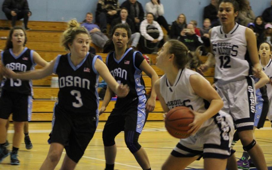 Seoul American's MacKenzie Barden looks to shoot against three Osan defenders during Saturday's Korea girls basketball game, won by the Falcons 39-38 on two Barden foul shots with .8 seconds left.
