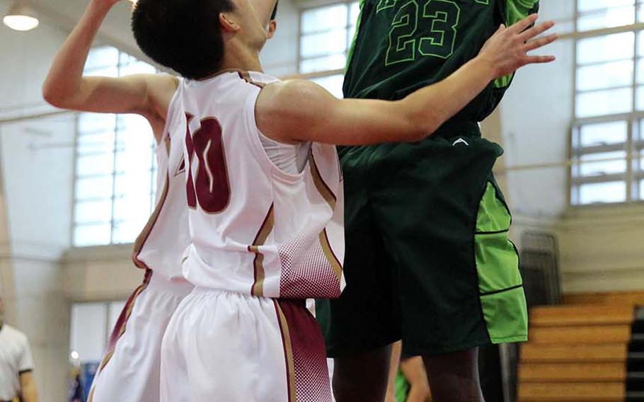 Kubasaki's Damian Dorval shoots over two Naha Kokusai defenders during Saturday's boys pool-play game in the 12th Okinawa-American Friendship Basketball Tournanment. The Dragons routed Naha Kokusai 66-40.