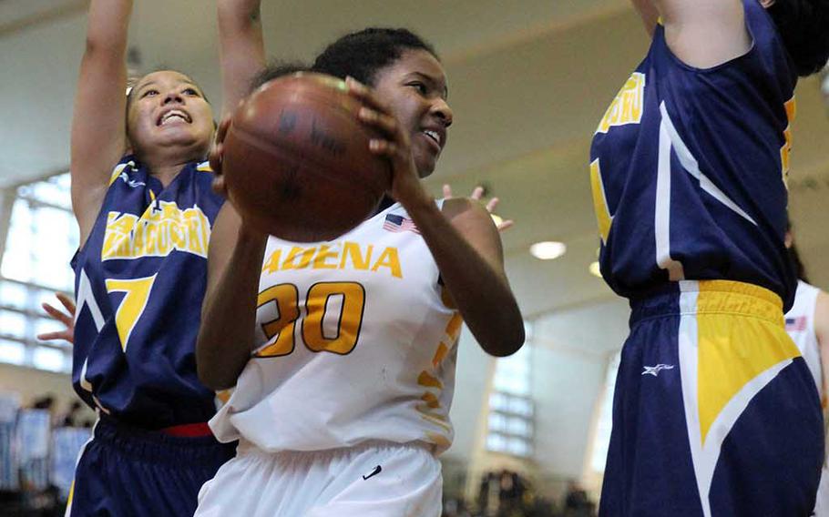 Kadena's Atiria Simms looks for room between two Kitanakagusuku defenders during Sunday's girls third-place game in the 12th Okinawa-American Friendship Basketball Tournament. The Panthers beat the Fighting Lions 62-53.